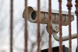 IP CCTV security camera and iron fence, urban cityscape photo