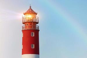 Lighthouse in Baltiysk port. Beautiful rainbow and beacon lights. Clean blue sky, copy space. photo