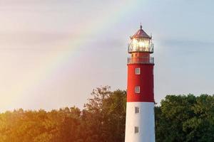 Lighthouse in Baltiysk port. Beautiful rainbow and beacon lights. Clean blue sky, copy space. photo