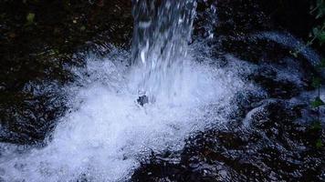 Jet of water falling into a water collection basin in slow motion video
