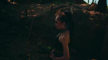 Beautiful Asian woman in green dress walking lonely between the big rocks and trees inside the forest at the mountain video