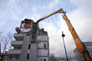 edificio de varios pisos demolido y desmantelado por máquina foto