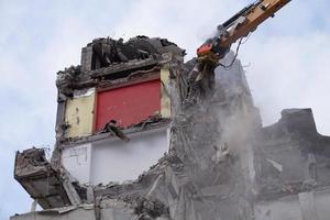 edificio de varios pisos demolido y desmantelado por máquina foto