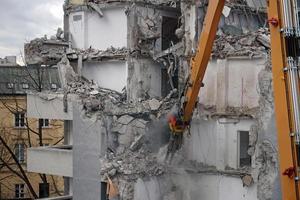 edificio de varios pisos demolido y desmantelado por máquina foto