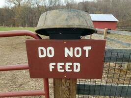 do not feed sign on wood fence at farm photo