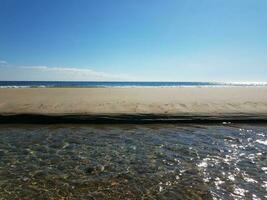 water flowing in river on beach near ocean photo