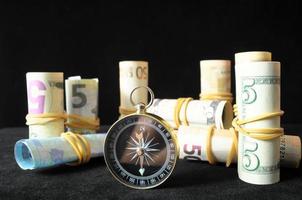 Cash and compass on black background photo