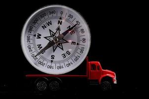 Toy truck carrying a compass on black background photo