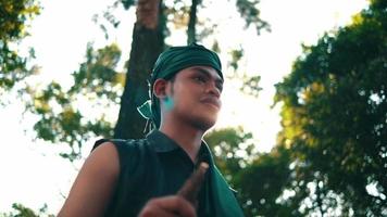 un homme asiatique avec des vêtements verts souriant tout en rencontrant sa femme dans la forêt avec un arbre en arrière-plan video