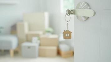 Moving house, relocation. The key was inserted into the door of the new house, inside the room was a cardboard box containing personal belongings and furniture. move in the apartment or condominium video