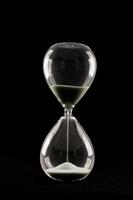 Isolated hourglass on black background photo