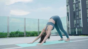 slank vrouw beoefenen yoga Aan de balkon van haar appartement. Aziatisch vrouw aan het doen opdrachten in ochtend. evenwicht, meditatie, ontspanning, kalm, mooi zo Gezondheid, Vrolijk, kom tot rust, gezond levensstijl concept video