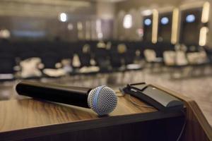 There is a microphone on the table against the background of an empty hall. photo