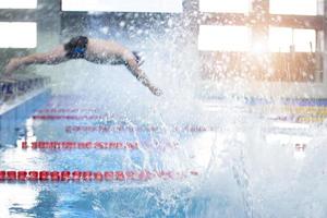 Blurred man is not an athlete dives in the pool into the water. photo