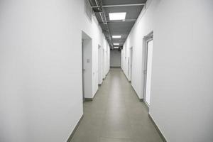 Empty white corridor with closed doors in an office building. photo