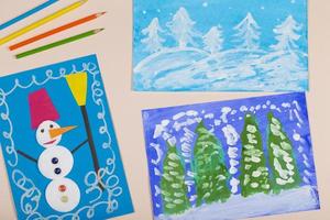 Collage of children's Christmas drawing. Application of children's creativity. Kindergarten and craft school. The child painted a winter Christmas tree and a snowman. photo