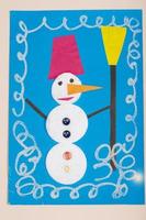 Children's Christmas paper crafts. Application of children's creativity. Kindergarten and craft school. On a beige background, a snowman made of colored paper. photo