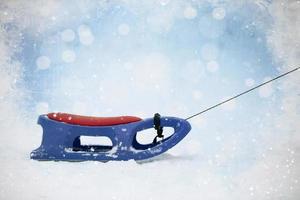 Snow sled on Christmas background.Blue and red plastic sleds photo