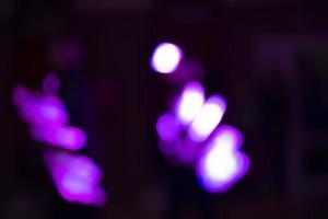 Purple and white spots of large bokeh on a black background. photo