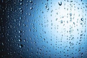 Water drops close-up on a blue glass background. photo