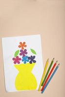 Paper crafts for children. Application of children's creativity. Kindergarten and craft school. On a beige background, a vase and flowers made of colored paper.