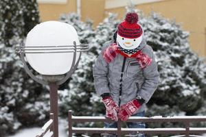 niño en invierno. niño pequeño con un sombrero de muñeco de nieve. foto