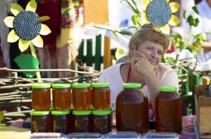 Belarus, Avtyuki village, July 31, 2021. Festival of culture. A woman sells honey. photo