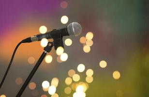 Stage retro microphone on a multicolored background in spots of golden bokeh. photo