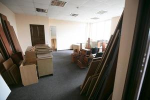 Lots of disassembled and scattered office furniture in an empty room. photo