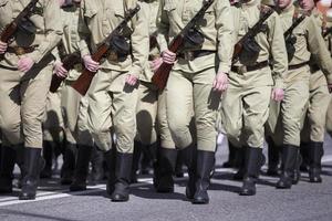 Russian soldiers in tarpaulin boots with weapons are in the ranks. photo