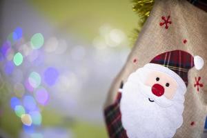 Funny santa claus made of cloth on colorful bokeh background. photo