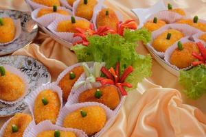 Kroket kentang is a traditional snack from Indonesia. served in wooden plate with green chilli. Delicious Indonesian Traditional Kroket Kentang with chilli photo