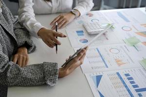 los empresarios explican los planes de trabajo usando gráficos y tabletas en la oficina. reunión para analizar y discutir y hacer una lluvia de ideas sobre los datos del gráfico del informe financiero en la oficina. foto