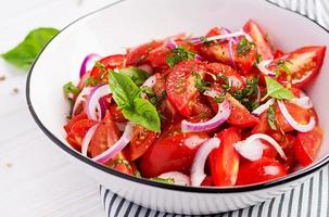 Tomato salad with basil and red onions. Homemade food.  Concept healthy meal. Vegan cuisine. photo