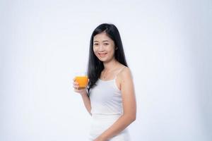 Beautiful asian woman drinking orange juice, healthcare, skin, beauty and wellbeing concepts, isolated on white background photo
