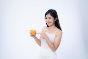 Beautiful asian woman drinking orange juice, healthcare, skin, beauty and wellbeing concepts, isolated on white background photo