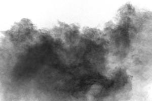 Black powder explosion against white background.Charcoal dust particles cloud. photo