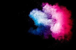 Freeze motion explosion of blue pink dust on  black background. Stopping the movement of colorful powder cloud. photo