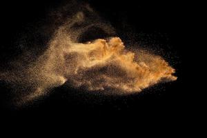 Dry river sand explosion. Brown colored sand splash against  black background. photo