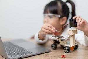Asia students learn at home in coding robot cars and electronic board cables in STEM, STEAM, mathematics engineering science technology computer code in robotics for kids concept. photo