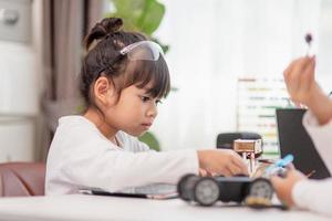 Asia students learn at home in coding robot cars and electronic board cables in STEM, STEAM, mathematics engineering science technology computer code in robotics for kids concept. photo