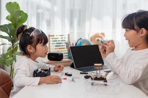 los estudiantes de asia aprenden en casa a codificar autos robot y cables de tableros electrónicos en tallo, vapor, ingeniería matemática, ciencia, tecnología, código de computadora en robótica para el concepto de niños. foto