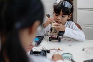 Asia students learn at home in coding robot cars and electronic board cables in STEM, STEAM, mathematics engineering science technology computer code in robotics for kids concept. photo