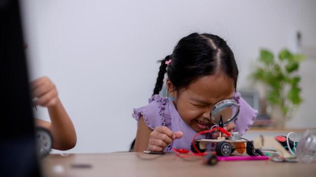 Asian students learn at home by coding robot cars and electronic board cables in STEM, STEAM, mathematics engineering science technology computer code in robotics for kids' concepts. photo