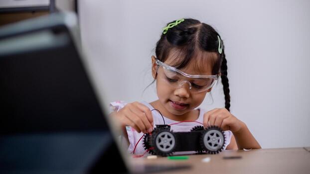 Asian students learn at home by coding robot cars and electronic board cables in STEM, STEAM, mathematics engineering science technology computer code in robotics for kids' concepts. photo