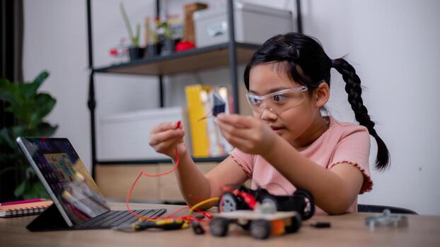 Asian students learn at home by coding robot cars and electronic board cables in STEM, STEAM, mathematics engineering science technology computer code in robotics for kids' concepts. photo