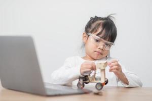 los estudiantes de asia aprenden en casa a codificar autos robot y cables de tableros electrónicos en tallo, vapor, ingeniería matemática, ciencia, tecnología, código de computadora en robótica para el concepto de niños. foto