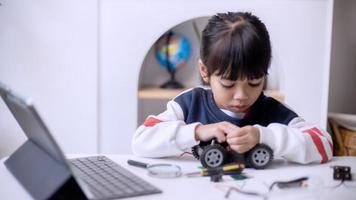 Asia students learn at home in coding robot cars and electronic board cables in STEM, STEAM, mathematics engineering science technology computer code in robotics for kids concept photo