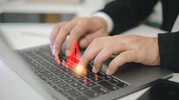 Computer notification error maintenance concept. programmer, or developer using a computer laptop with a triangle warning exclamation red sign trouble caution. photo