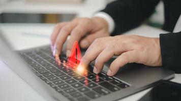 Computer notification error maintenance concept. programmer, or developer using a computer laptop with a triangle warning exclamation red sign trouble caution. photo